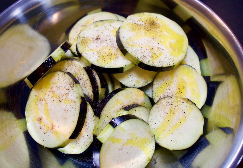 Eggplant slices coated with oil and salt and pepper.