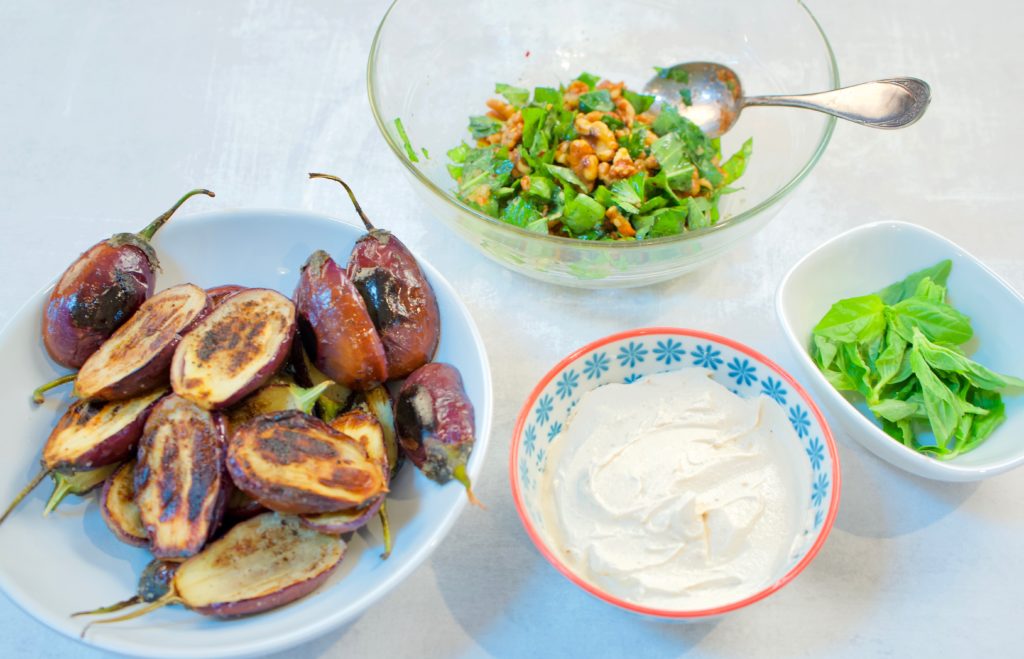 cooked mini eggplant, walnut basil topping, tahini yogurt, fresh basil leaves