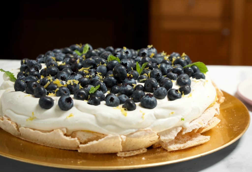 A lemon and blueberry pavlova that's perfect for spring or summer. lemon curd, blueberries, almond and mint adorn a marshmallowy meringue with sweet cream.
