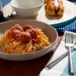 Turkey meatballs and spaghetti on table with meatball roll