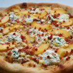 White Pizza with Peaches, Pancetta and Corn. Creamy ricotta and a garlic cream sauce create the perfect base for this pizza.