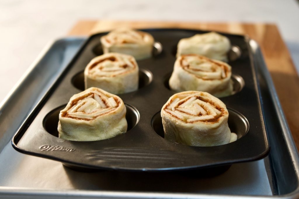 Puff pastry make these sticky buns easy. Filled with apples and cinnamon and topped with caramel and almonds, these are the perfect breakfast treat!