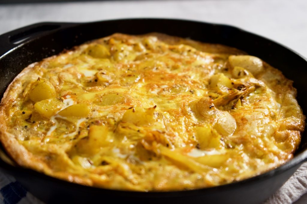 A potato frittata spiced with whole cumin, coriander and mustard seeds. Tender potatoes and sweet onions make this a delicious egg dish for any time of day or night!