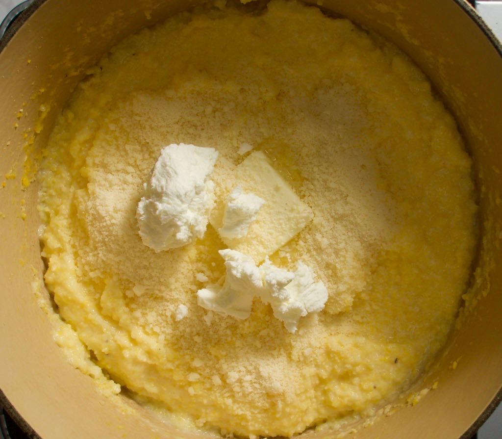 Cooked polenta with pats of butter, goat cheese and parmesan.