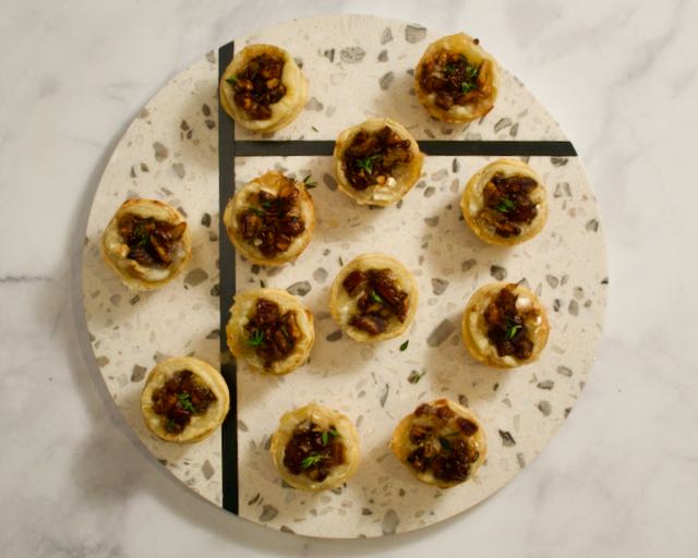 Brie tartlets on marble board.