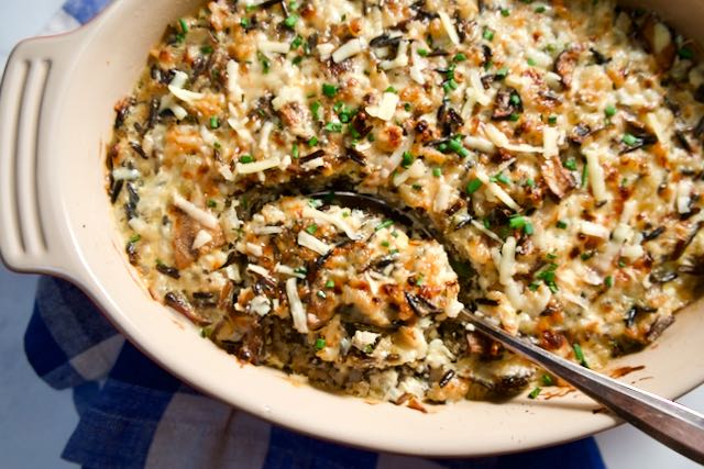 Spoon in baking dish with wild rice casserole.