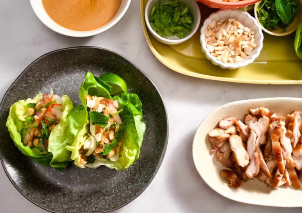 Lettuce wraps on plate, chicken on plate, garnishes.