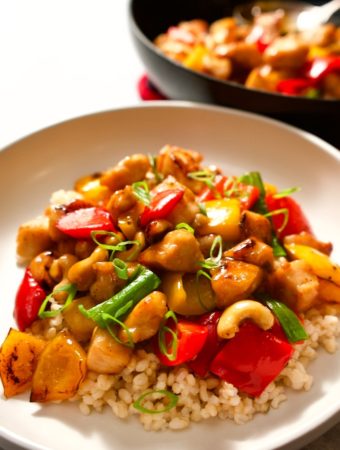 Chicken cashew stir fry over rice in a bowl.
