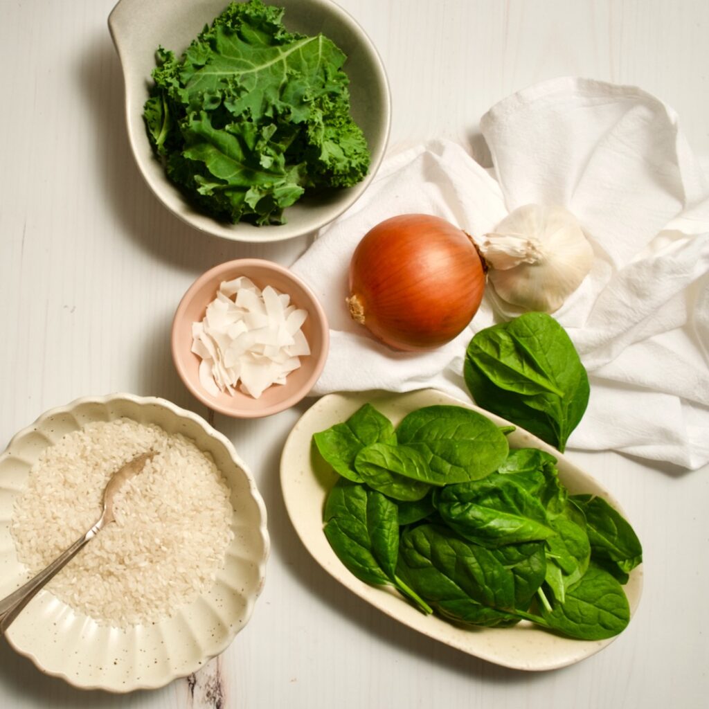 Spinach, onion, kale, garlic and raw rice on table with towel. 
