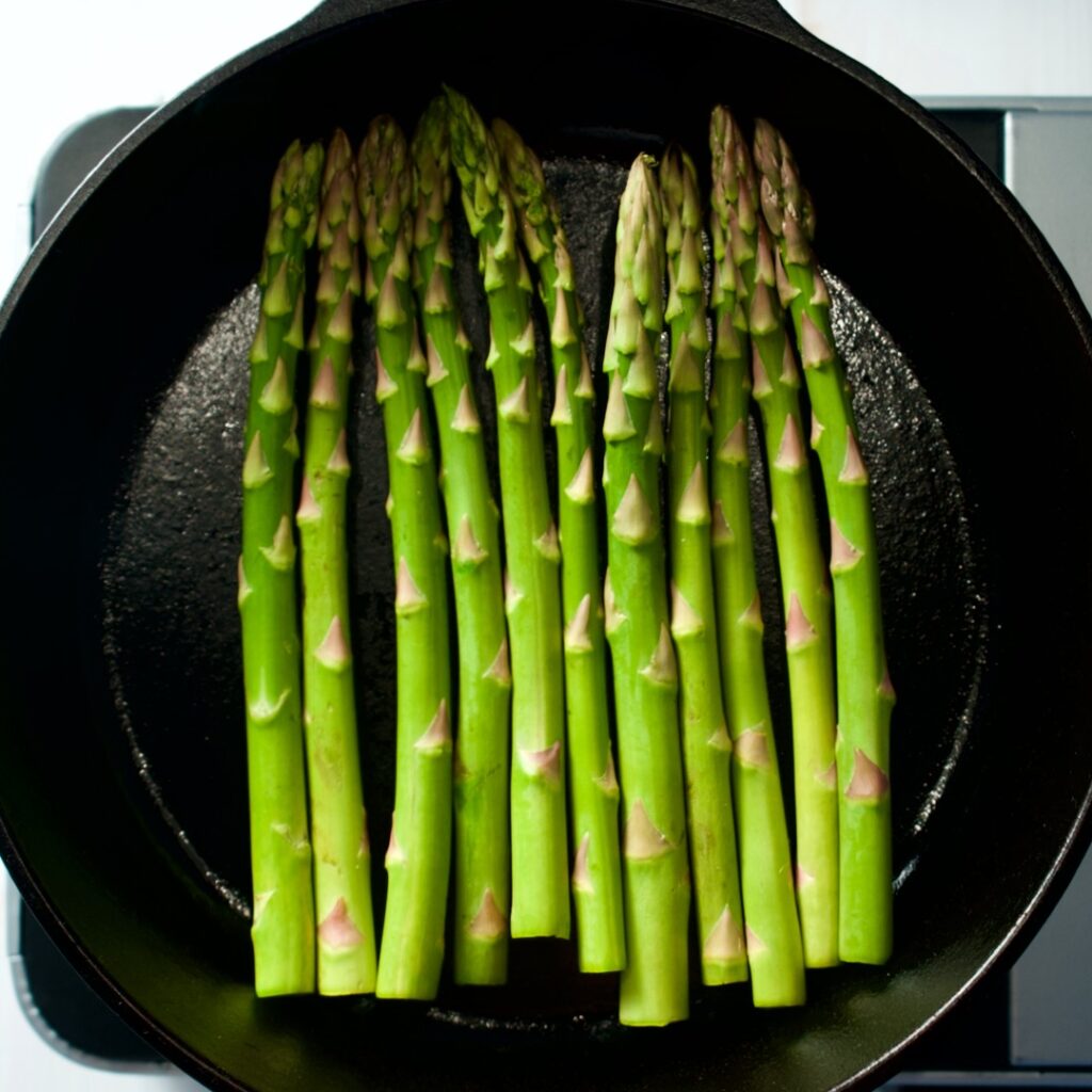 Asparagus spears in a cast iron pan.